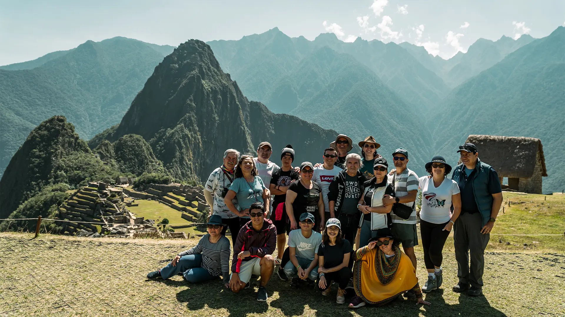 Grupo de viajeros frente a la ciudadela de Machu Picchu y las montañas de los Andes